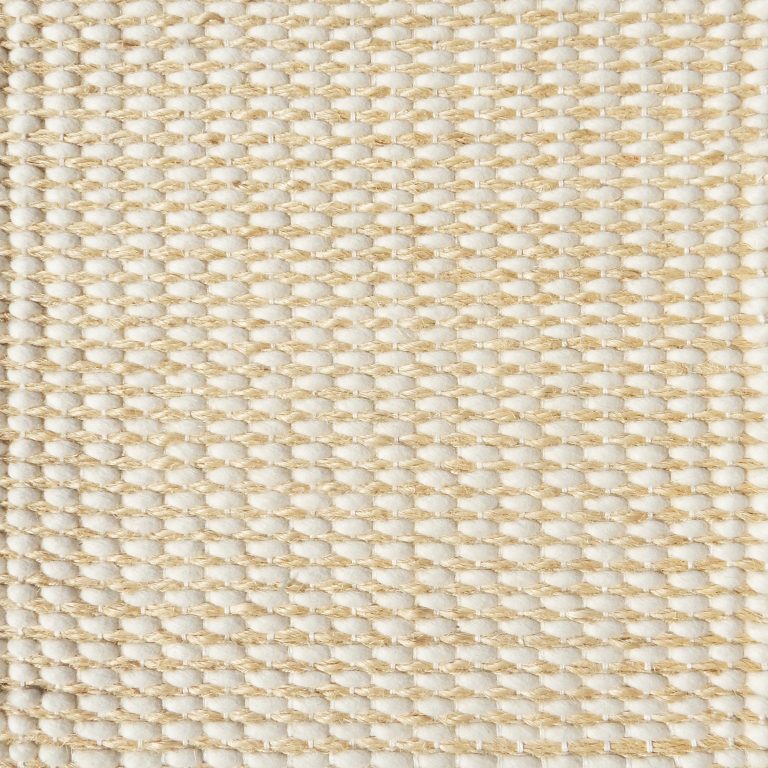 Detail of a textural rug in natural fiber and grey yarn.