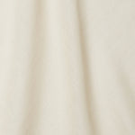 A draped swatch of open-weave sheer interior fabric in a mottled cream color.