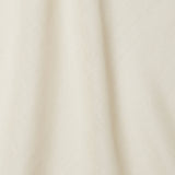 A draped swatch of open-weave sheer interior fabric in a mottled cream color.