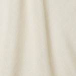 A draped swatch of open-weave sheer interior fabric in a mottled cream color.