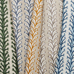 A row of folded fabric swatches, all in different colorways of the same striped branch pattern with tiny fruits.