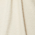Draped piece of high-pile bouclé fabric in cream.