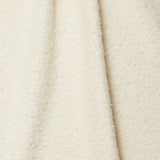 Draped piece of high-pile bouclé fabric in cream.