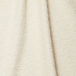 Draped piece of high-pile bouclé fabric in cream.