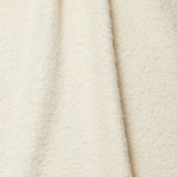 Draped piece of high-pile bouclé fabric in cream.