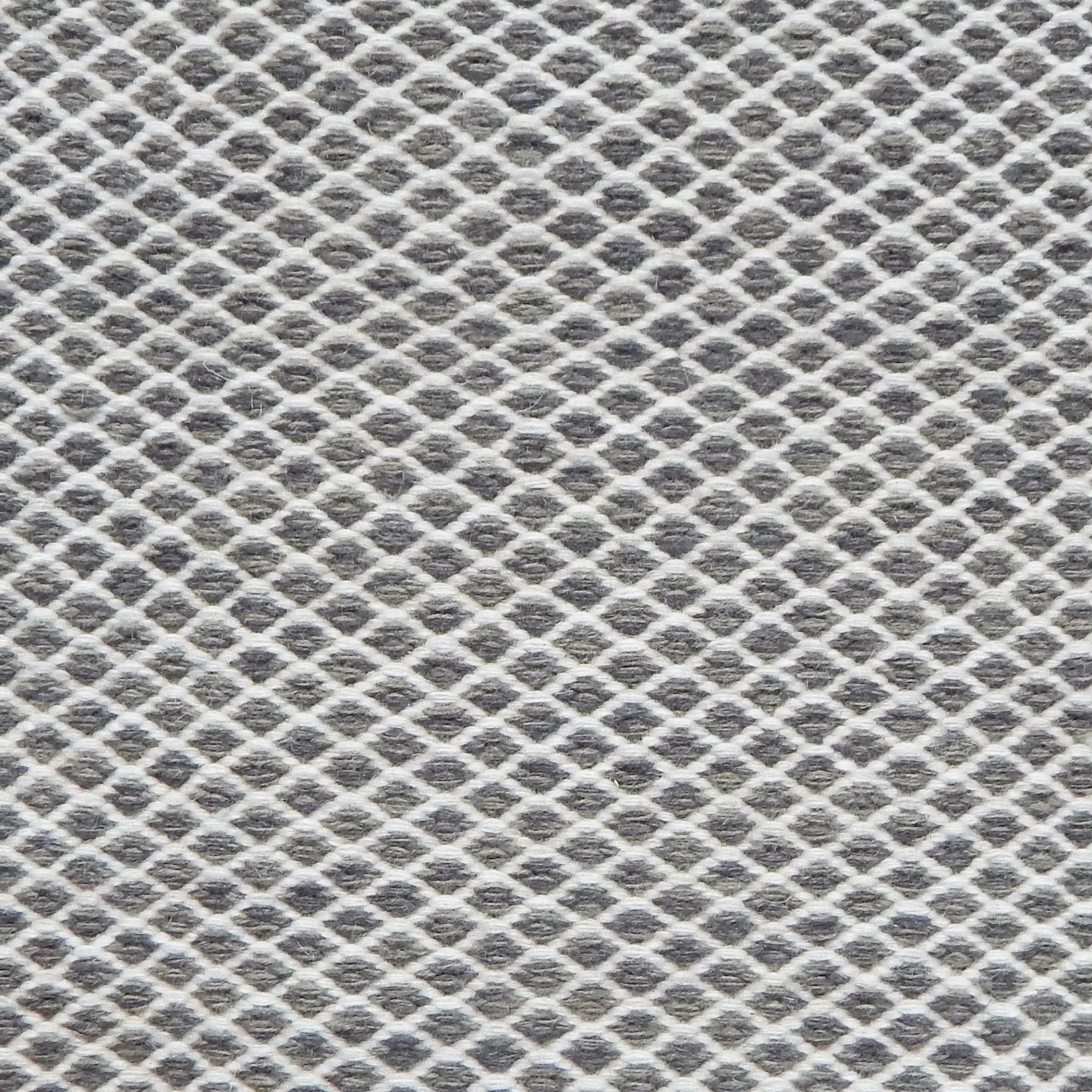 Flatweave rug with small scale lattice in white with charcoal grey field. 