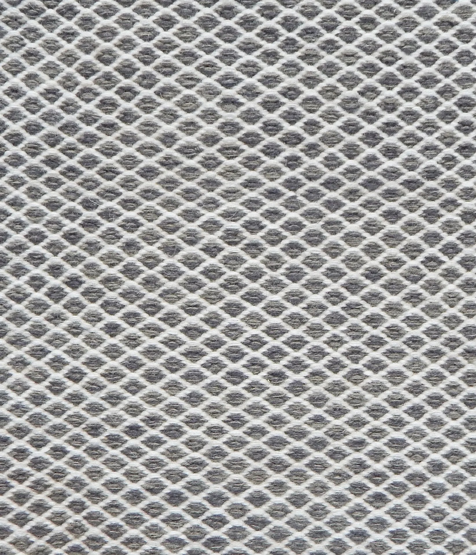 Flatweave rug with small scale lattice in white with charcoal grey field. 