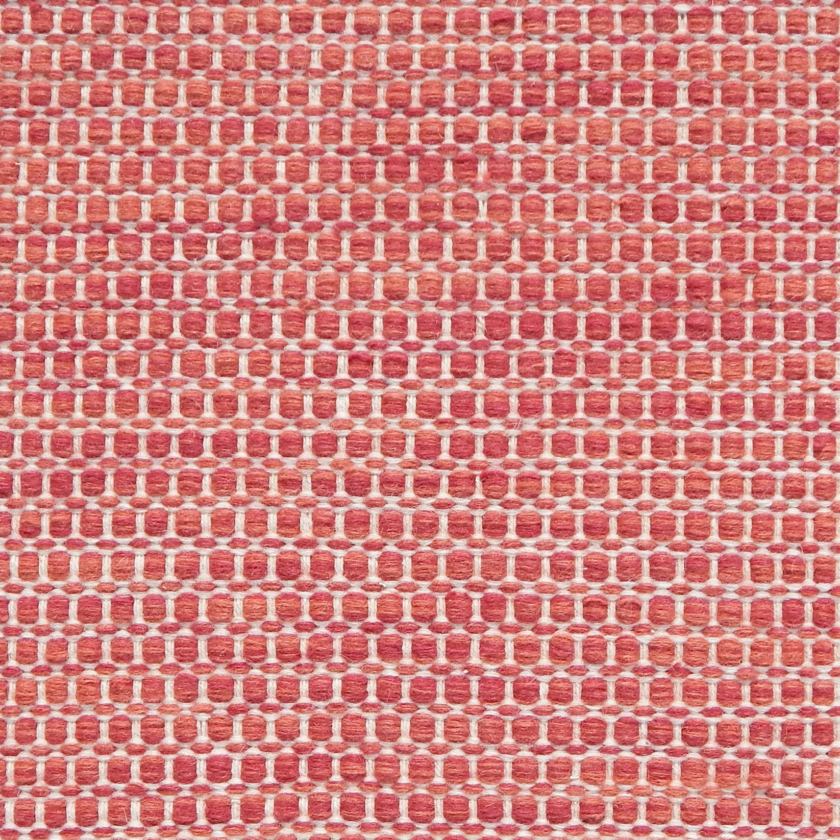 Textured handwoven carpet in bright coral red