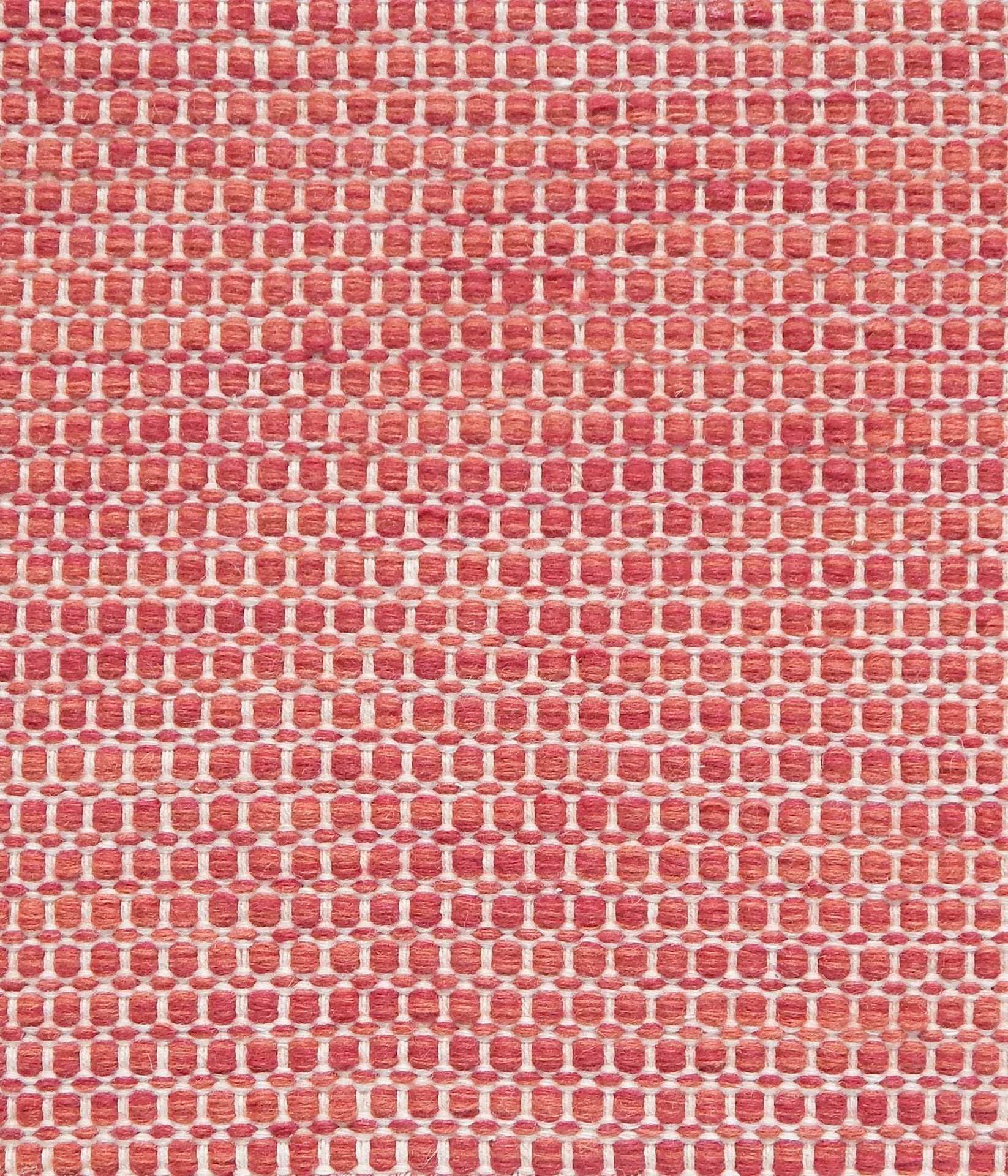 Textured handwoven carpet in bright coral red