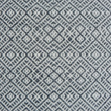 Flatweave rug with an intricate diamond pattern in white and charcoal grey.