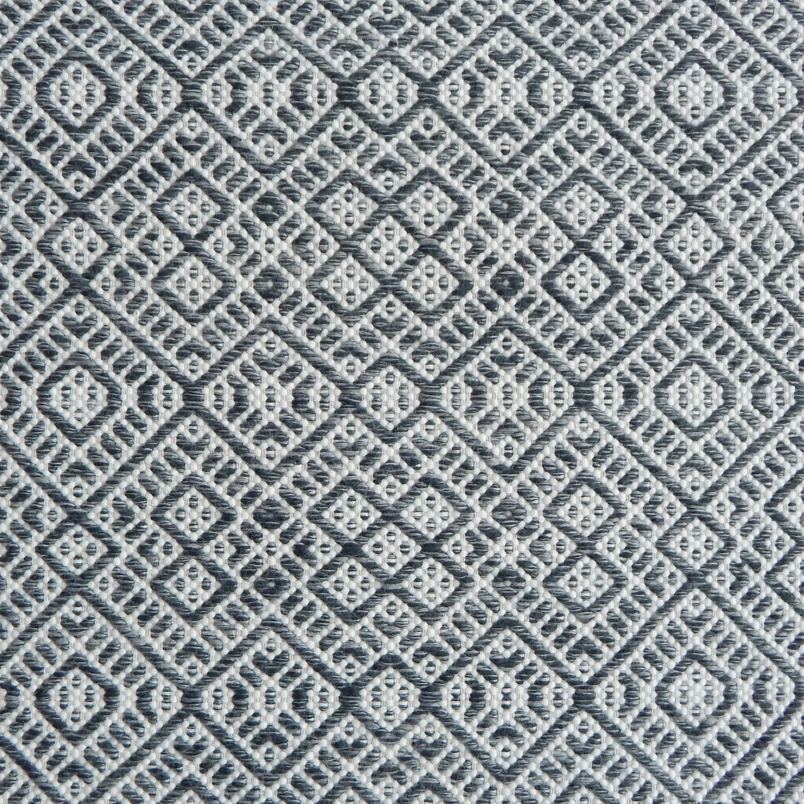 Flatweave rug with an intricate diamond pattern in white and charcoal grey.