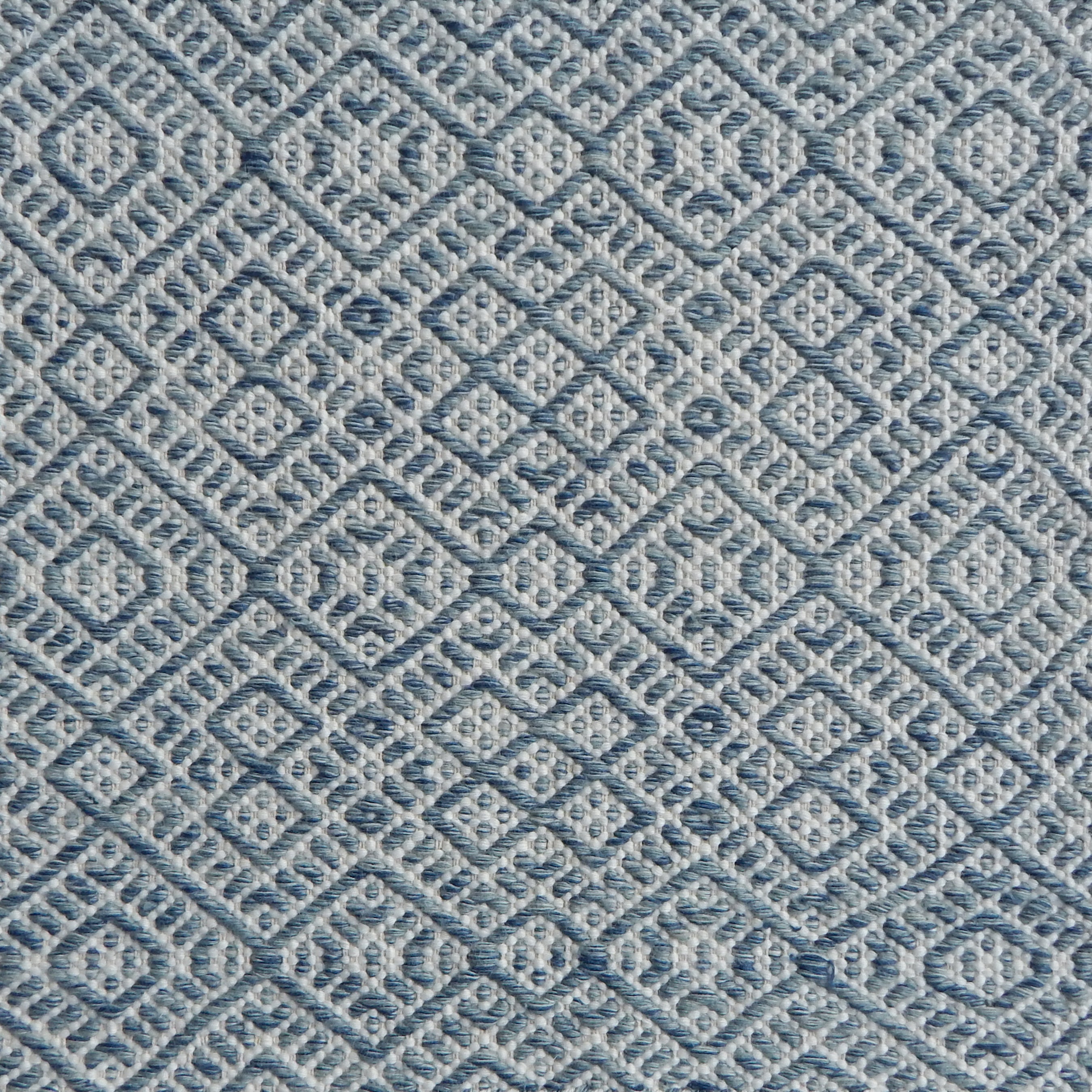 Flatweave rug with an intricate diamond pattern in white and teal