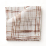 Fabric swatch with watercolor plaid pattern in shades of brick red. 