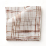 Fabric swatch with watercolor plaid pattern in shades of brick red. 