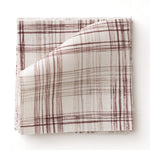 Fabric swatch with watercolor plaid pattern in shades of wine red.