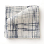 Fabric swatch with watercolor plaid pattern in shades of blue. 