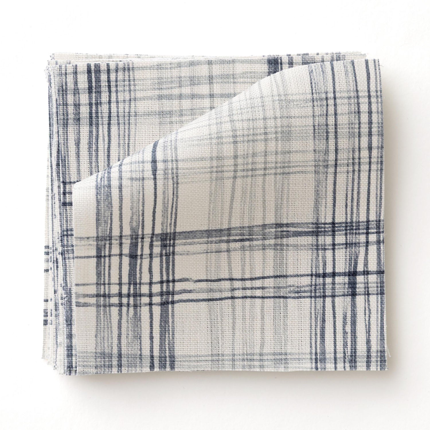 Fabric swatch with watercolor plaid pattern in shades of blue. 