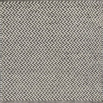 Textured rug with a herringbone pattern in white and dark grey.