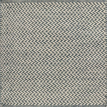 Textured rug with a herringbone pattern in white and teal.