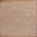 Textured rug with a herringbone pattern in white and orange.