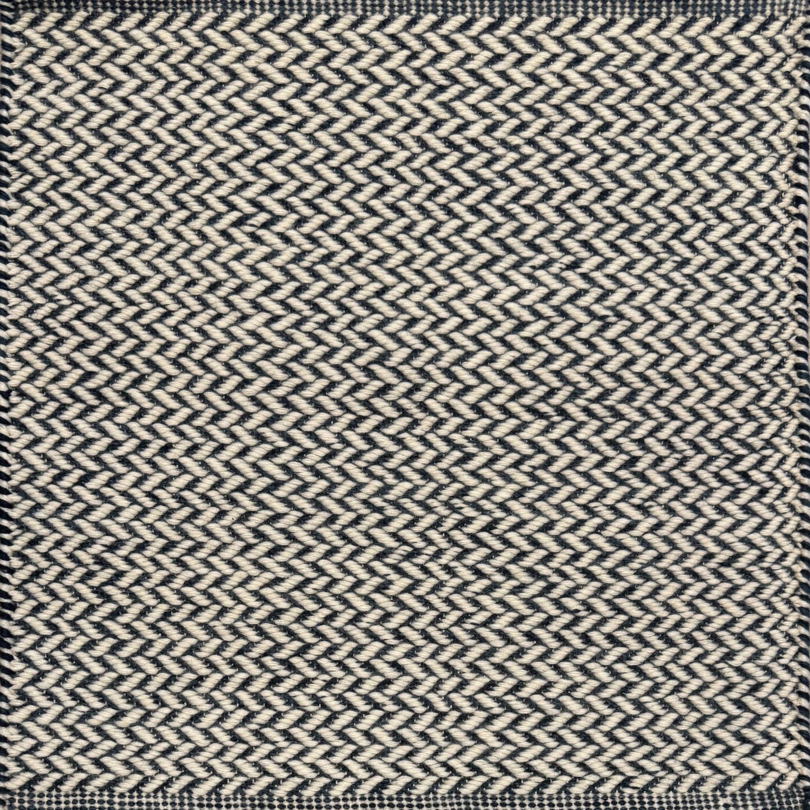 Textured rug with a herringbone pattern in white and navy blue