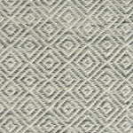 Detail of handwoven rug with diamond pattern in cream and shades of grey-blue.
