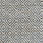 Detail of handwoven rug with diamond pattern in cream and shades of blue and brown.