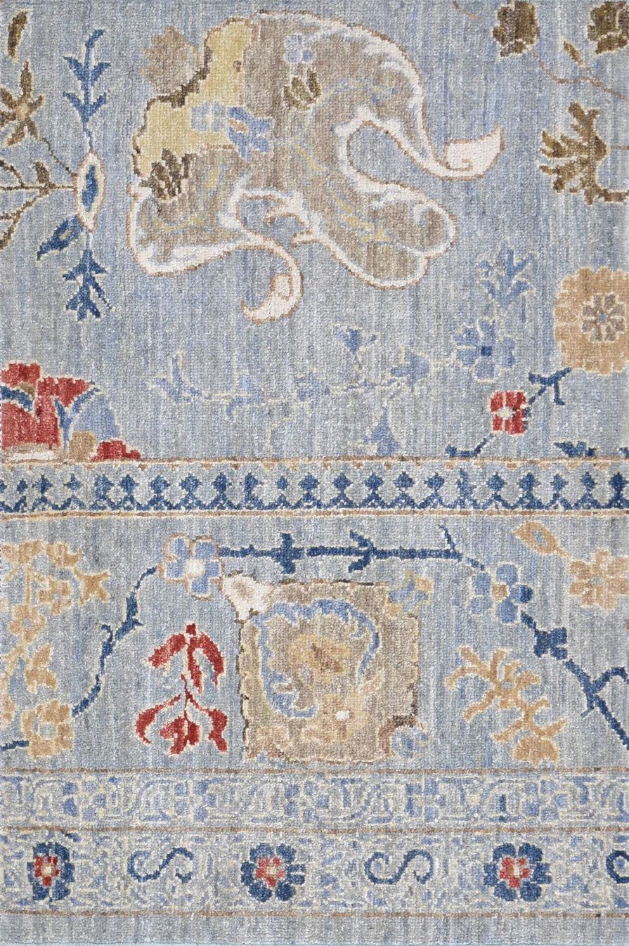 Decorative rug with floral and geometric patterns in blue, beige, and red on a light background