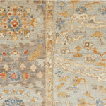 Detail of a Handknotted rug with an ornate Damascus design in blue, grey, and tan. 