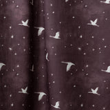 Draped fabric in a flying geese and star pattern in white on a deep eggplant purple watercolor field.