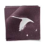 Fabric swatches in a flying geese and star pattern in white on a deep eggplant purple watercolor field.