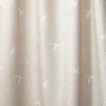 Draped fabric in a flying geese and star pattern in white on a pale ecru watercolor field.