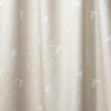 Draped fabric in a flying geese and star pattern in white on a pale ecru watercolor field.