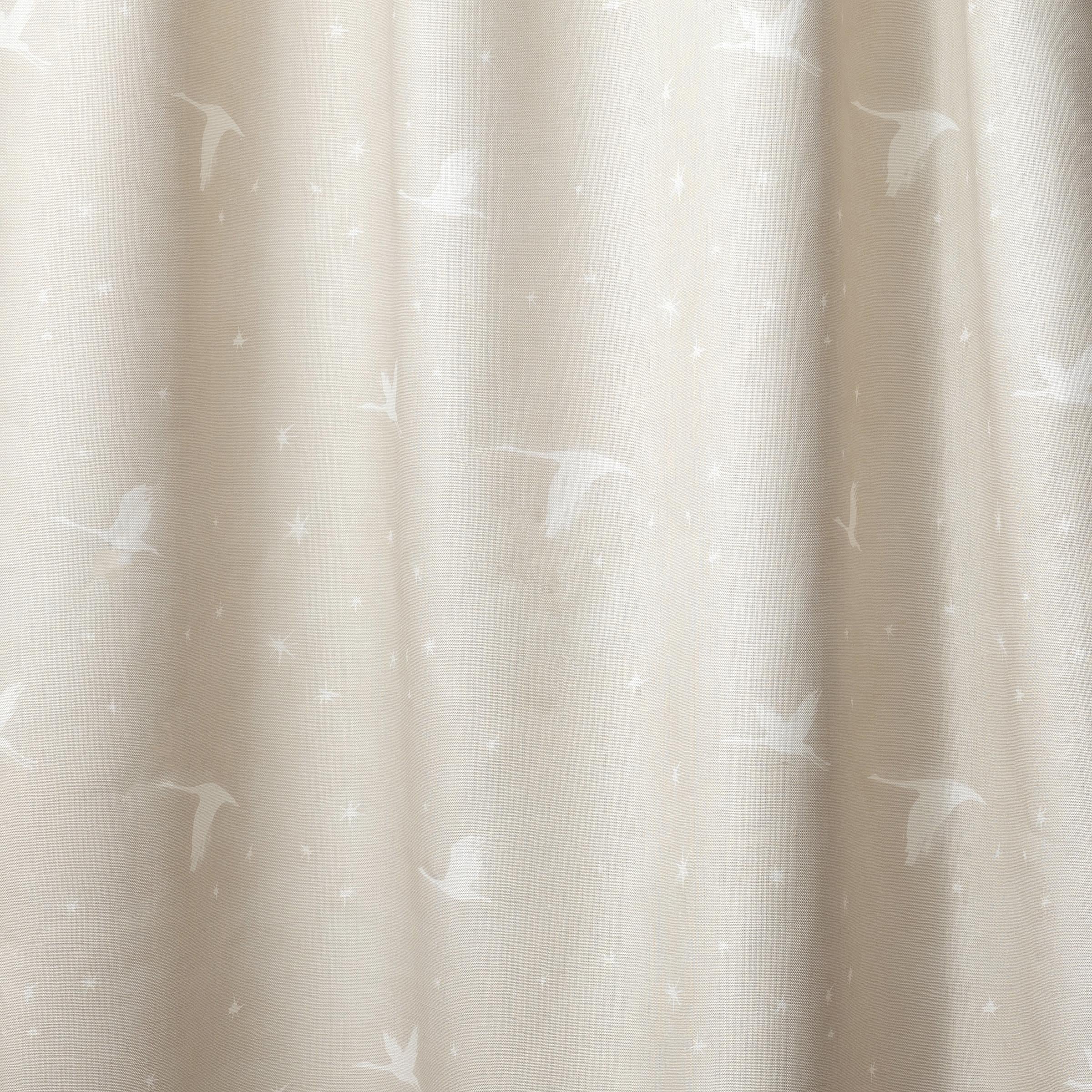 Draped fabric in a flying geese and star pattern in white on a pale ecru watercolor field.