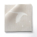 Stack of fabric swatches in a flying geese and star pattern in white on a pale ecru watercolor field.