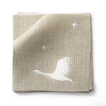 Fabric swatches in a flying geese and star pattern in white on a taupe watercolor field.