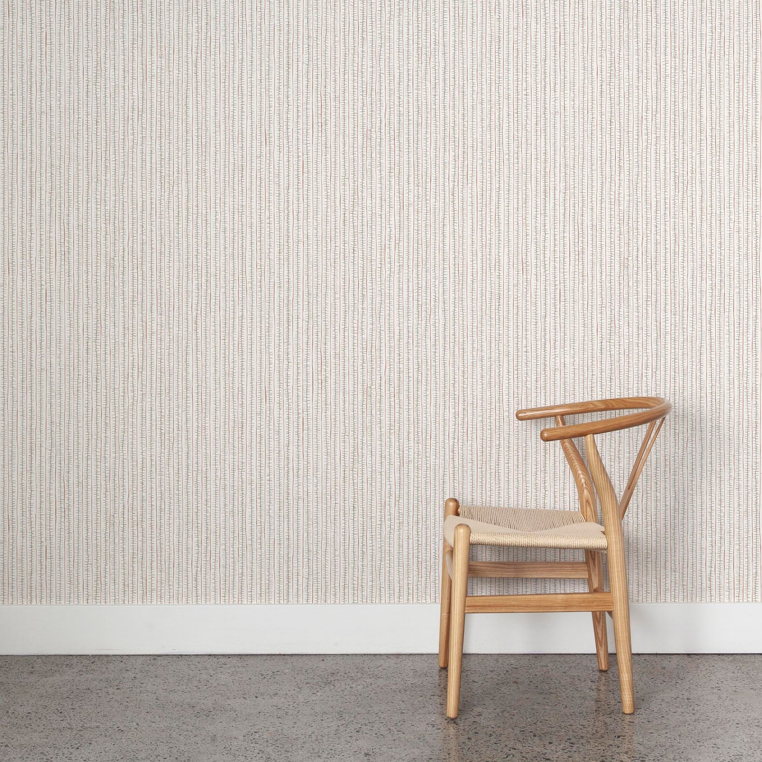 Wooden chair against wallpaper with hand drawn ticking stripe in  grey and rust red on white. 