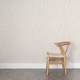 Wooden chair against wallpaper with hand drawn ticking stripe in  grey and rust red on white. 