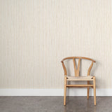 Wooden chair against wallpaper with hand drawn ticking stripe in  yellow and grey on white. 