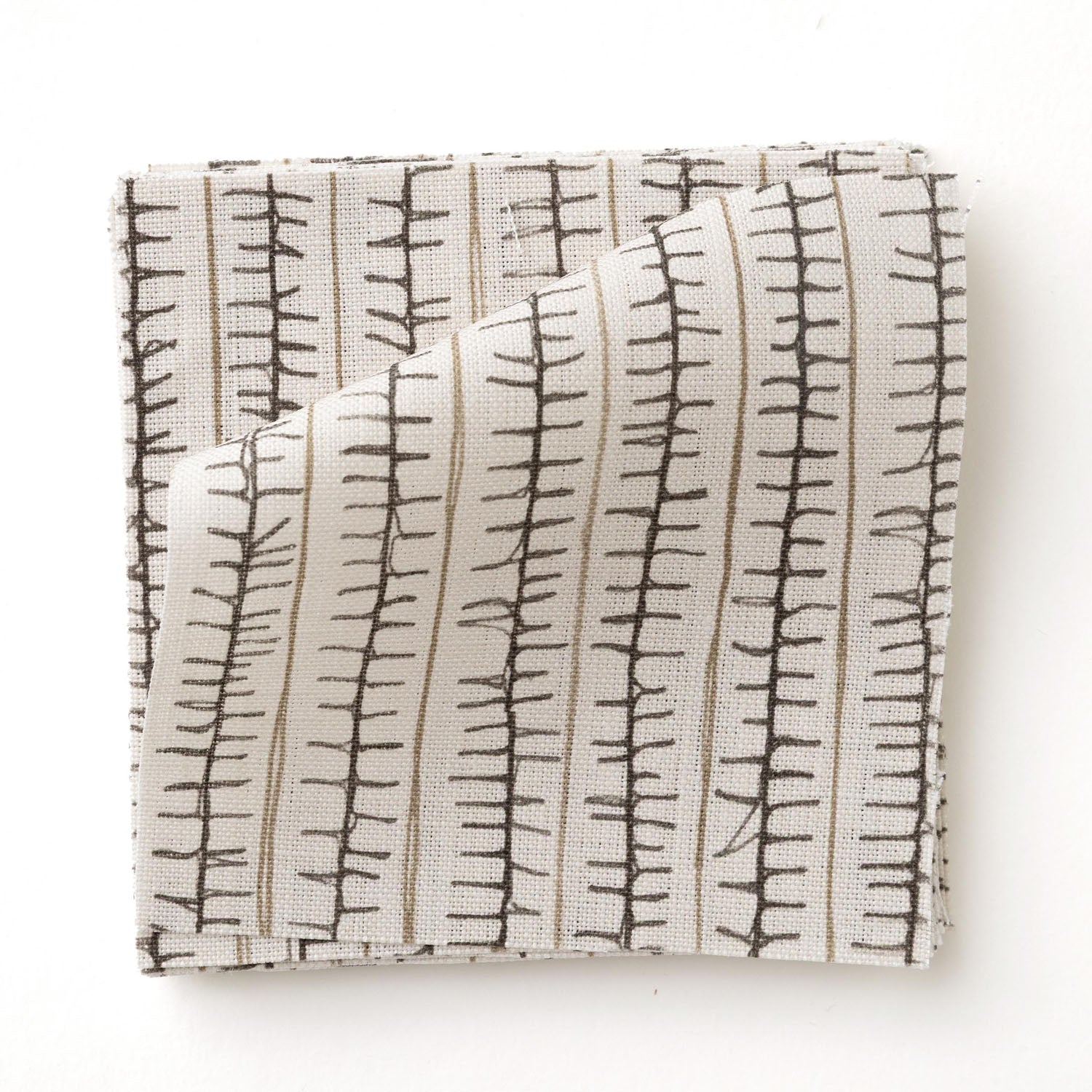 Swatch of fabric with hand drawn ticking stripe in black and taupe on white.