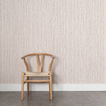 Wooden chair against wallpaper with hand drawn ticking stripe in dark purple and tan on white. 