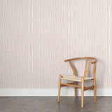 Wooden chair with rope seat against a striped wallpaper.