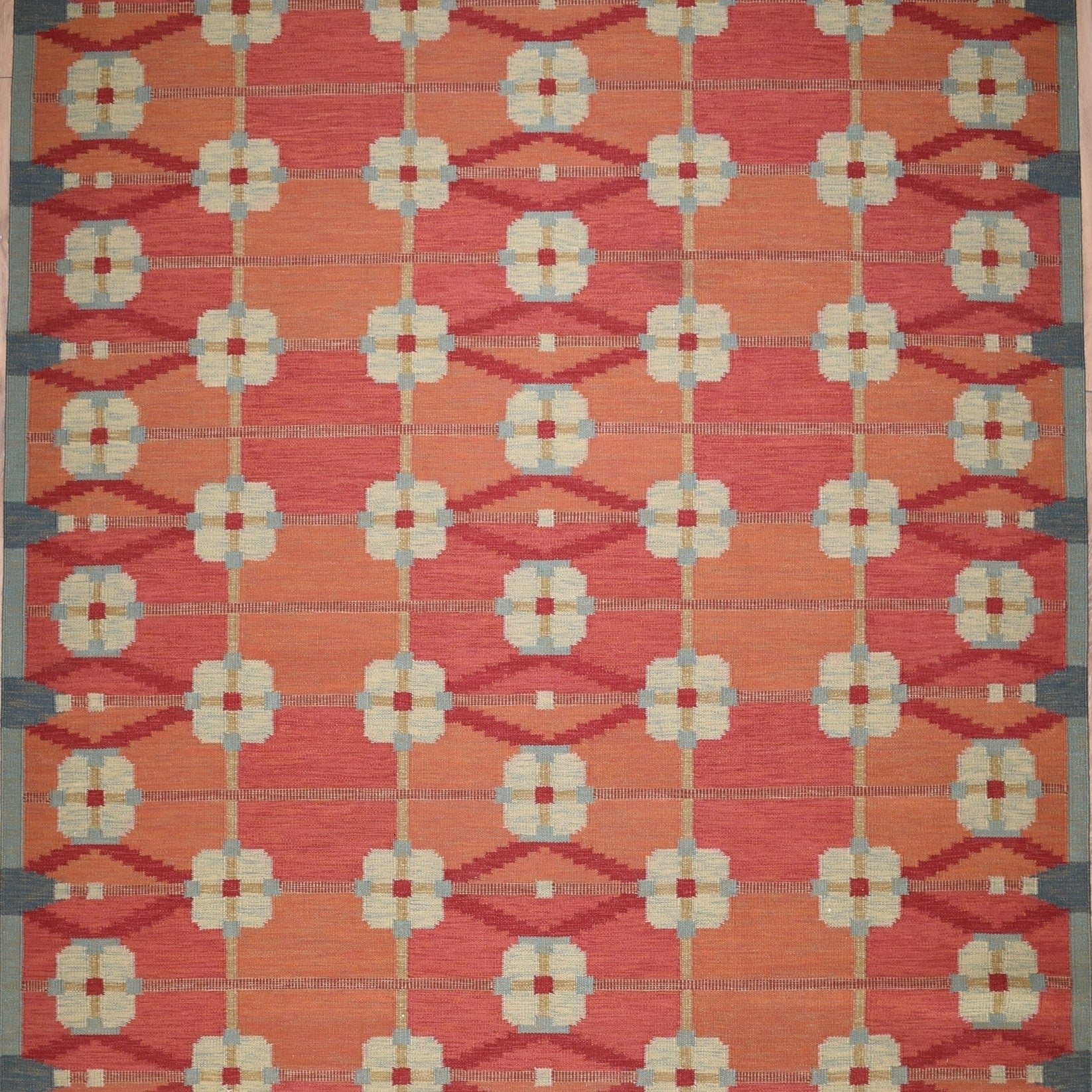 Decorative rug with geometric pattern on a red background