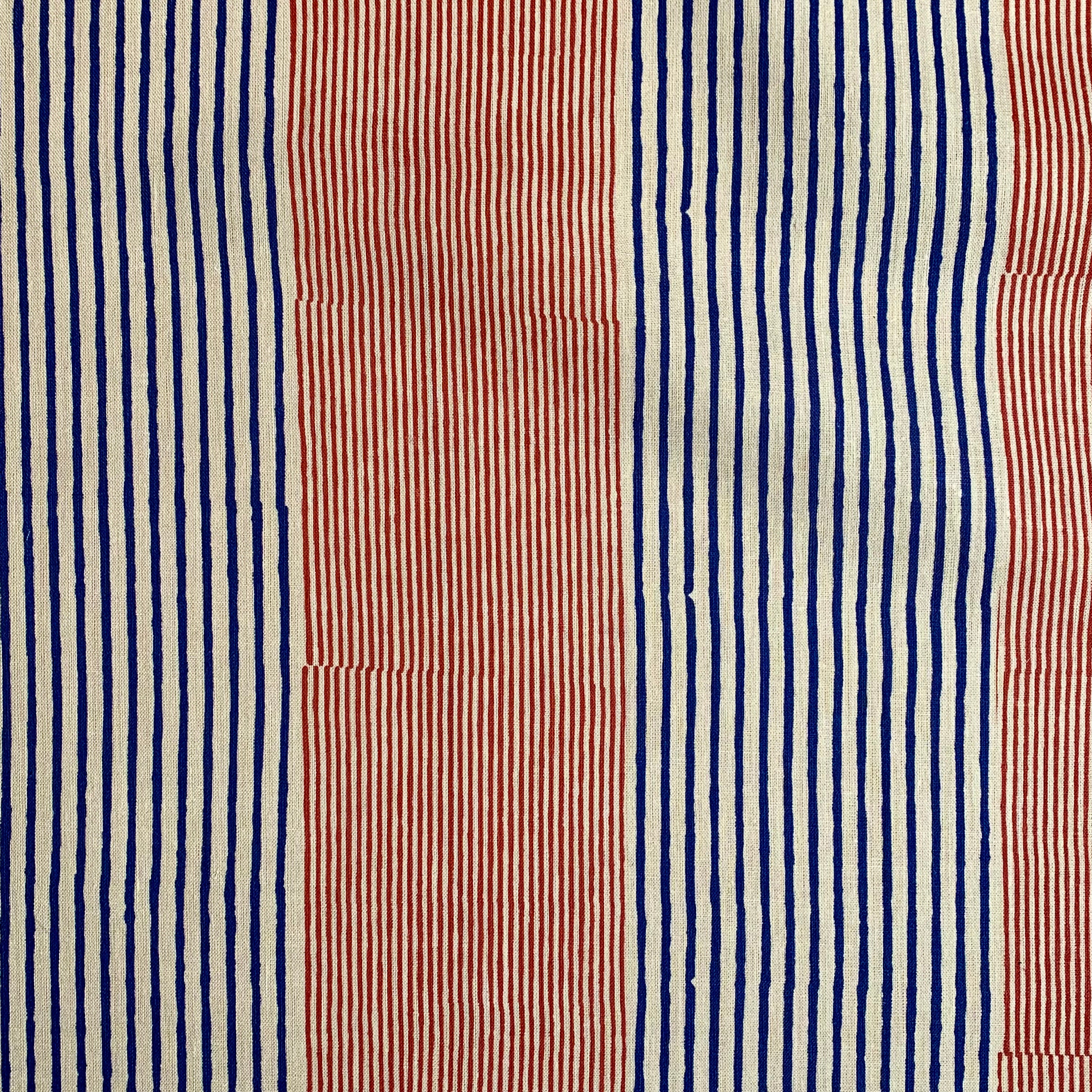 Detail of fabric in an irregular stripe print in red and navy on a white field.