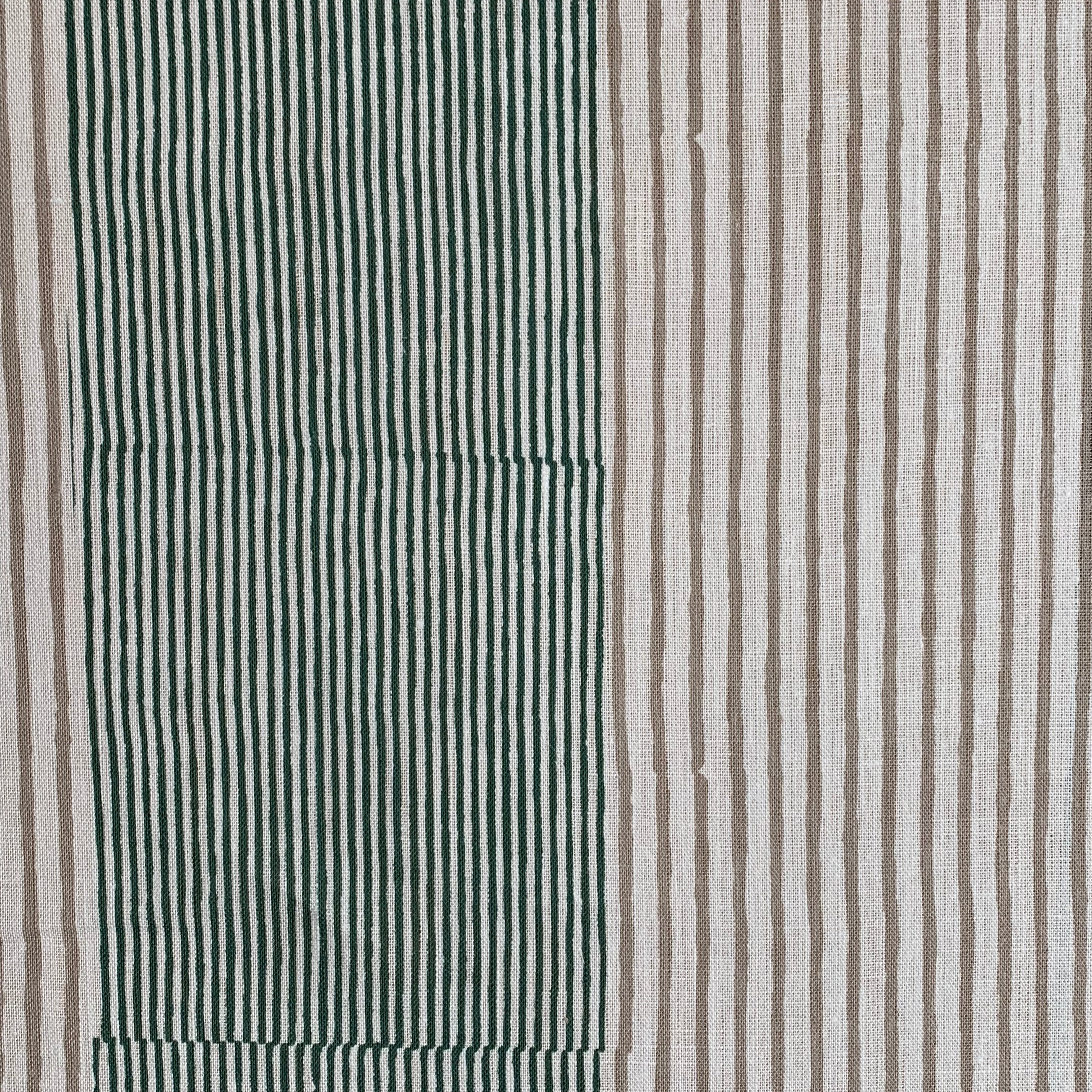 Detail of fabric in an irregular stripe print in green and brown on a white field.