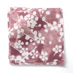 Fabric swatches in a painterly branch print in white on a berry red watercolor field.