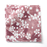Fabric swatches in a painterly branch print in white on a berry red watercolor field.