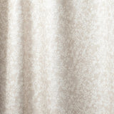 Draped fabric in a painterly branch print in white on an ecru watercolor field.