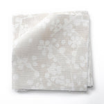 Fabric swatches in a painterly branch print in white on an ecru watercolor field.