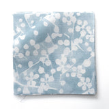 Fabric swatches in a painterly branch print in white on soft blue watercolor field.